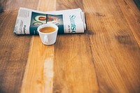 Morning coffee by the newspaper on a wooden table