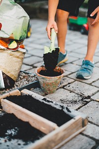 Man putting mud into a flower pot