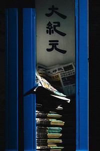 Stacked Chinese newspapers behind blue doors