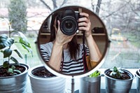 Woman taking a mirror selfie of her camera