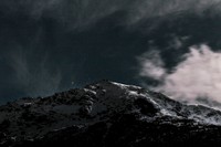 Cloudy night sky over a white summit