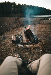 Man enjoying the bonfire by a lake
