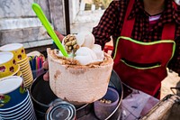 Woman serving fresh coconut ice cream in young coconut