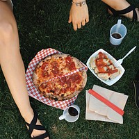 Woman eating salami pizza on the grass