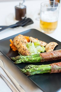 Chicken breast with bacon-wrapped asparagus  and a glass of beer