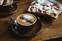 Hot cappuccino with chocolate powder and a waffle