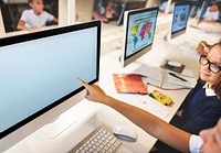 Elementary school student pointing at a computer with an empty screen