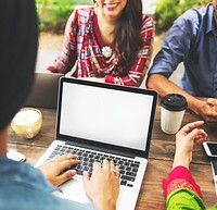 Blank white laptop screen with friends in the background