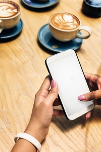 Woman in a cafe using a smartphone with an empty screen