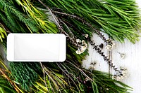 Mobile phone on top of fir leaves