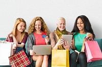 Women on digital devices with their shopping bags