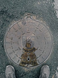 Overhead view of a manhole cover after it has rained.