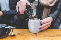 Free woman pouring coffee into mug photo, public domain beverage CC0 image.