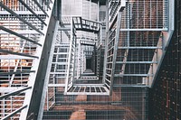 Looking down through the center of a tall fire escape, free public domain CC0 image.