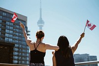 Women hold up Canadian flags, free public domain travel CC0 photo.