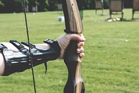 Free arm holding an archer's bow with protective gear photo, public domain building CC0 image.