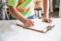 A construction worker goes over plans on site of a condominium build.