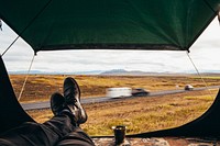 Relaxing in a tent, next to the highway. Camping the Iceland way as other cars race past.