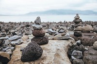 Stones stacked high on a rocky beach. They make small sculptures for whoever passes by to enjoy.