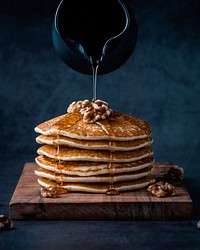 Free pouring honey on pancakes with walnuts image, public domain food CC0 photo.