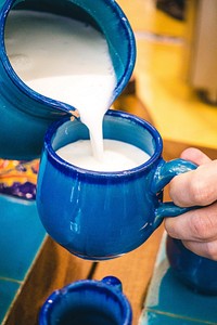 Free pouring yogurt drink into blue porcelain cup photo, public domain beverage CC0 image.