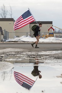 Airman 1st Class Nathaniel Powers, an aerospace medical technician assigned to the 673d Medical Operations Squadron, carries the U.S. flag while completing a five-mile ruck at Joint Base Elmendorf-Richardson, Alaska, April 7, 2018. Powers, a native of Collierville, Tenn., rucks every Friday from the JBER hospital to his dormitory to maintain his physical fitness - and carries the U.S. flag to honor the sacrifices of veterans past. (U. S. Air Force photo by Alejandro Peña). Original public domain image from Flickr