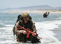Canadian Army Master Corporal Paul Tremblay, a member of the Canadian 2nd Battalion Royal 22e Régiment (22nd Regiment) Reconnaissance team secures the beach amphibious landing training on rigid hull inflatable boats at Blue Beach training area during the biennial Rim of the Pacific (RIMPAC) Exercise at Marine Corps Base Pendleton, California, July 8, 2018.