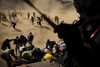 A U.S. Navy aircrewman attached to Helicopter Sea Combat Squadron 26 drops humanitarian aid in support of earthquake relief efforts in Port-au-Prince, Haiti, Jan. 17, 2010.