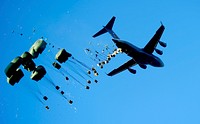 A U.S. Air Force C-17 Globemaster III aircraft drops pallets of water and food over Mirebalais, Haiti, Jan. 21, 2010, to be distributed by members of the United Nations.