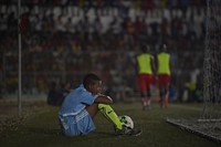 A ball boy sits behind the goal net in the finals of the Mogadishu District Football Tournament between the Waaberi and Shibis districts on the evening of 24 September, 2018.