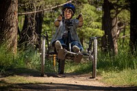 Woman uses a hand bike to explore the accessible barrier-free trails of the Thompson Park area of Beaverhead-Deerlodge National Forest. Original public domain image from Flickr