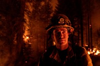 Cal State firefighter takes a break after raking vegetation and pine needles from large trees to mitigate the spread of fire during the Donnell Fire, Stanislaus National Forest, California. Original public domain image from Flickr