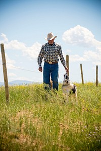 Dennis Kleinjan, rancher near Chinook, Mont., uses electric fence to divide his place into different pastures to rotate his cattle to better use his grazing land. June 2017. Blaine County, Montana. Original public domain image from Flickr