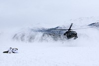 U.S. Army Paratroopers with the 1st Squadron, 40th Cavalry Regiment (Airborne), 4th Infantry Brigade Combat Team (Airborne), 25th Infantry Division, U.S. Army Alaska, huddle to protect a mock casualty from the rotor-wash of a landing UH-60 Black Hawk helicopter at Joint Base Elmendorf-Richardson, Alaska Feb. 20, 2019.