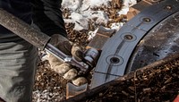 A contractor uses a wrench to tighten the massive saw teeth of the circular saw of a feller buncher at the U.S. Department of Agriculture (USDA) Forest Service (FS) Kaibab National Forest, Williams Ranger District's Cougar Park Task Order worksite, in Arizona, on December 4, 2018.