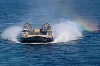 Landing craft air cushion 58, assigned to Assault Craft Unit (ACU) 5, flies on the water as it approaches the San Antonio-class amphibious transport dock ship USS John P. Murtha (LPD 26) in the Pacific Ocean, March 30, 2019.