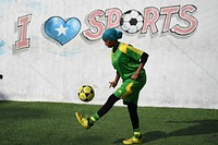 A female soccer player dribbles a ball during a training session for Golden Girls Football Club in Mogadishu, Somalia on February 18, 2017. Original public domain image from Flickr