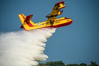 An Canadair CL-215 (Scooper) drops water during Aerial Firefighting Demo at the 2019 EAA AirVenture Oshkosh July 24, 2019, in Oshkosh, Wisconsin.