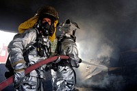 Fire fighters from the 447th Expeditionary Civil Engineer Squadron extinguish a fire in a training room during live-burn training at Baghdad International Airport, Iraq, Aug. 9, 2010.