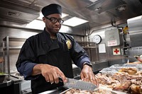 MEDITERRANEAN SEA (Nov. 28, 2019) – Senior Chief Culinary Specialist Corey Montgomery cuts a turkey in preparation for Thanksgiving dinner aboard the Arleigh Burke-class guided-missile destroyer USS Ross (DDG 71) Nov. 28, 2019.