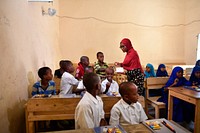 Ulrike Kahbila Mbuton, the AMISOM Human Rights Officer, distributes stationery at Qamar Primary School, in Mogadishu, Somalia on 19 December 2019. AMISOM Photo / Omar Abdisalan. Original public domain image from Flickr