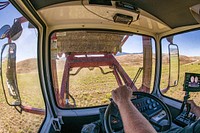 Steve Burke, Jr., uses stacker equipment to quickly collect the big straw bales at P&amp;J Ranches where his father Producer Steve Burke (black baseball cap) and other landowners use water from the Ruby Reservoir at the base of the Ruby Mountains where water flows along the West Bench Canal, just above the mountain base, above the farmlands; along the way, improved U.S. Department of Agriculture (USDA) funded control valves allow water through debris grates and additional (self-cleaning) rotating cylindrical algae filter screens before entering inlets to funded Irrigation Water Management systems and into the (gravity-flow) Irrigation Pipeline that supplies five center-pivot and one wheel-line Sprinkler System without the use of pumps in Sheridan, MT, on August 28, 2019.