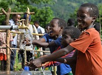 In Malle woreda of South Omo, a region inhabited mainly by pastoralists, children enjoy water access for the first time from a simple hand-pump water system developed by the USAID Lowland WASH Activity. Credit: Michael Tewelde/USAID. Original public domain image from Flickr