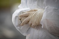 Medical technician adjusts her gloves at a COVID-19 Community-Based Testing Site. Original public domain image from <a href="https://www.flickr.com/photos/matt_hecht/49696562868/" target="_blank">Flickr</a>