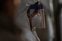 New Jersey National Guard Soldiers and Airmen go over the wear of protective equipment at a COVID-19 Community-Based Testing Site at the PNC Bank Arts Center in Holmdel, N.J., March 23, 2020.