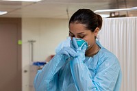 Hospitalman wears a face mask aboard the hospital ship USNS Mercy (T-AH 19) before working with a patient.(U.S. Navy photo by Mass Communication Specialist 2nd Class Abigayle Lutz). Original public domain image from Flickr