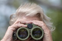 Arizona Elk Society Founding Board Member and Vice President Tice Supplee, uses a natural blind to camouflage herself while she uses binoculars to look for wildlife near Cattle Grazing Permittee Rancher Rodney Wayne Porter's tin roof rainwater harvesting system facility in the U.S. Department of Agriculture (USDA) Forest Service (FS) Apache-Sitgreaves National Forests, where the Heber Wild Horse Territory is home to many feral horses in high central Arizona area, on Sept. 27, 2019.