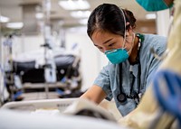 Woman treating a patient in an intensive care unit aboard the hospital ship USNS Mercy (T-AH 19). (U.S. Navy photo by Mass Communication Specialist 2nd Class Ryan M. Breeden). Original public domain image from Flickr