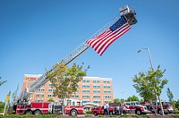 Firefighters with the city of Seneca raise a flag before two South Carolina Air National Guard “Swamp Fox” F-16 fighter jets fly over the Oconee Memorial Hospital in Seneca, SC as part of Operation American Resolve: Swamp Fox Salute to COVID-19 Responders, April 27, 2020. (Photo by Ken Scar). Original public domain image from Flickr