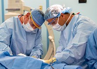 200418-N-PH222-1789 LOS ANGELES (April 18, 2020) Cmdr. Gavin Dunn, from St. Louis (left) and Lt. Cmdr. Patrick Morrissey, from San Diego, perform a surgery on a patient in an operating room aboard the hospital ship USNS Mercy (T-AH 19).